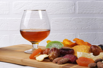 mix of dried fruits and nuts on a dark wood background. tinting. selective focus.