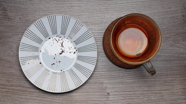 Drinking of black tea from a teacup on a white background and white plate with cookies star shaped- Stop motion. TIME LAPSE cup of tea. 