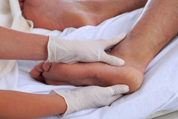 Healthcare environment with caregiver checking patients foot