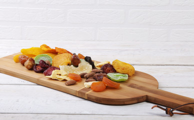 mix of dried fruits and nuts on a dark wood background. tinting. selective focus.