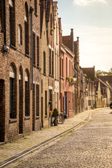 Tourists walking at typical Belgian streets in Bruges with beautiful architecture