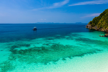 Fototapeta premium Aerial drone view of a boat moored off a beautiful, deserted tropical island