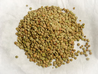 Close up of dried green lentils on white background.