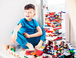 little cute preschooler boy playing constructor toys at home happy smiling, lifestyle children concept close up