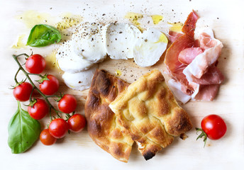 Italian antipasti; Cheese mocarella, focaccia, Prosciutto di Parma basil and tomatoes