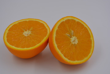 Bright orange halves of sliced ripe orange, two halves of whole orange, wholesome food and fruit, healthy food.