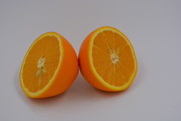 Bright orange halves of sliced ripe orange, two halves of whole orange, wholesome food and fruit, healthy food.