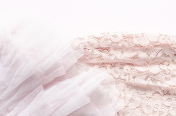 Soft pink tulle and lace fabrics texture on pink background.