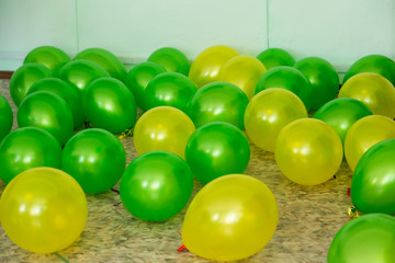 Balloons of two colors green and yellow lie on the floor.
