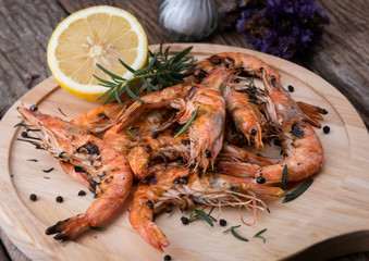 Shrimps or prawns grilled in wooden plate.