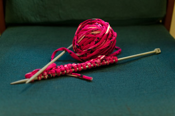 Crochet and skeins of yarn isolated on a sofa
