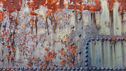 close-up of old weathered and rusty industrial metal with rivets background