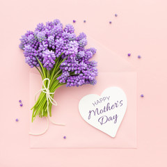 Spring lilac flowers and a heart shape card Happy Mother's Day on pink envelope.