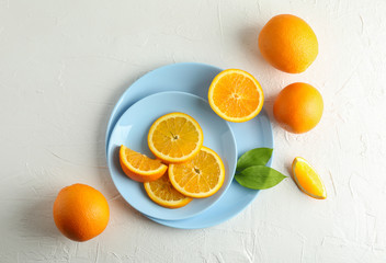 Plates with orange slices on white background. Top view, space for text