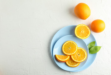 Plates with orange slices on white background. Top view, space for text