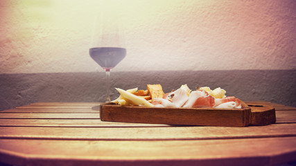 Obraz na płótnie Canvas Italian food on a wooden chopping with a red wine glass