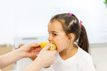 Little girl eats corn