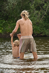 father teaching his little son to swim, they are happy.