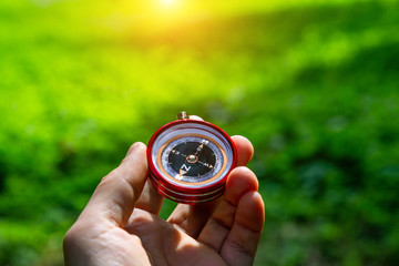 Tourist compass in his hand outdoors in the forest.