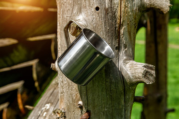 Tourist steel cup in the summer forest outdoors.