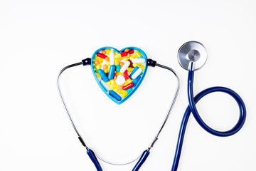 Stethoscope, pharmaceutical medicine pills, tablets, capsules on white background. Medication,...