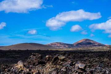 Spain, Lanzarote, Colorful volcanic mountain scenery surrounded by endless lava fields in timanfaya...