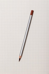 white checked notebook and gray pencil closeup