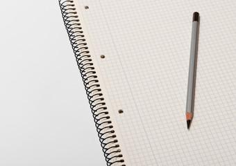 white checked notebook and gray pencil on white background