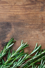 Rosemary herb on a wooden background, copyspace. Fresh rosemary Board. Top view