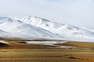 Fototapeta premium China, Tibet, the snowy peaks of the coast of mountain lake Kering in the summer when the weather is cloudy