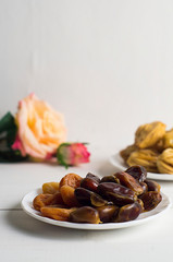 Sweets, dates, dried apricots on a plate. Flower. The concept of Ramadan, iftar.