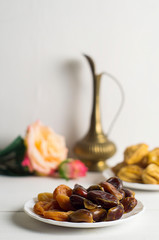 Sweets, dates, dried apricots on a plate. Flower. The concept of Ramadan, iftar.