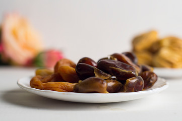 Sweets, dates, dried apricots on a plate. Flower. The concept of Ramadan, iftar.