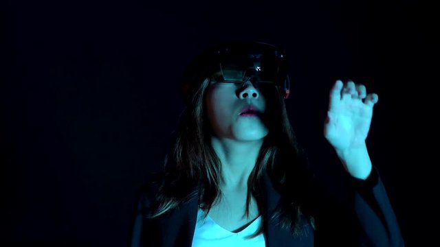 Business woman try vr glasses hololens in the dark room | Portrait of young asian girl experience ar communication | Future technology concept