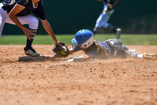 Young high school softball players in action, making amazing plays, during a game