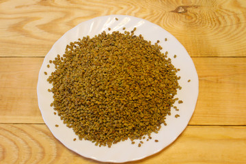 Egyptian yellow tea or Helba in a plate on a wooden table
