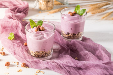 Healthy breakfast parfait with yogurt, granola and nuts in glass