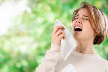 Ill woman with napkin sneezing