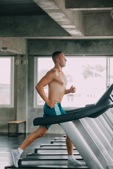 Fototapeta na wymiar Running . young man running on treadmill at gym