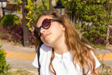 Pretty young girl with sunslasses chilling out in park