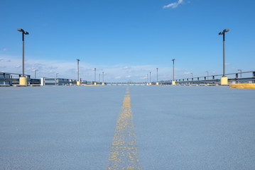 Fototapeta na wymiar Open air rooftop garage. Industrial building roof top parking. Empty open space parking lot. 