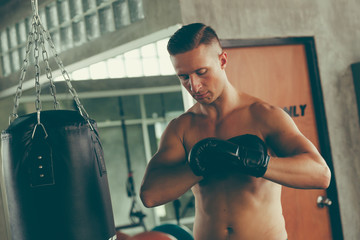 young strong sports man boxer make exercises in gym