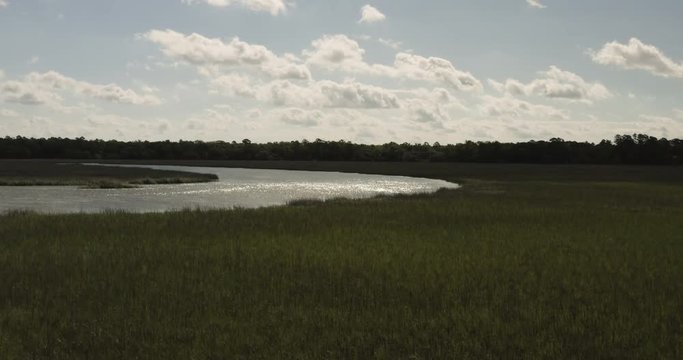 Slow fly over wide river and green marsh grass, 4k aerial drone footage of southern Georgia intracoastal waterways.
