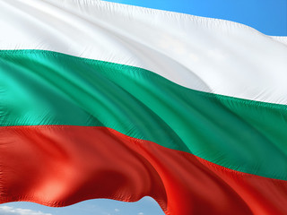 Obraz premium Flag of Bulgaria waving in the wind against deep blue sky. High quality fabric.