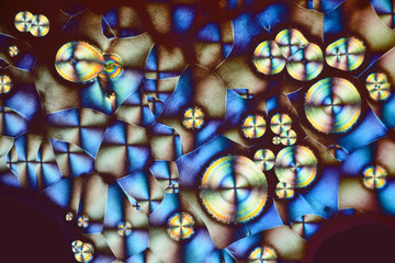Colorful micro crystals in polarized light. Photo through a microscope.