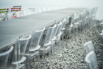 The transparent chairs for the party are rows on the beach