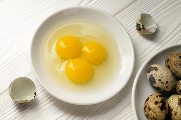 Top view white plate with quail eggs and dish with whole eggs