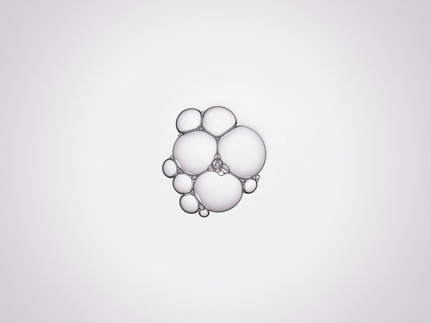 Bulles de savon en macrophotographie, bulles de taille variable connect&eacute;es entre elles sur un fond neutre