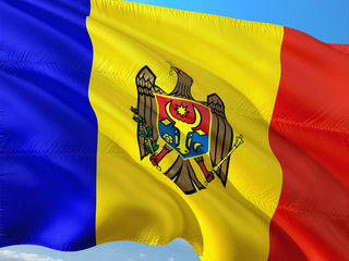 Flag of Moldova waving in the wind against deep blue sky. High quality fabric.