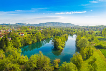Fototapeta na wymiar Beautiful rural landscape, Croatian river Mreznica and village of Belavici from air, peaceful water surface and woods